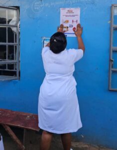 Nurse putting up poster regarding mpox