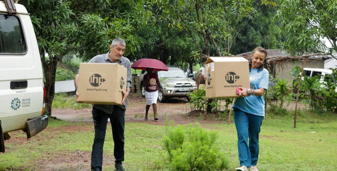 Two people carrying boxes with IHP label