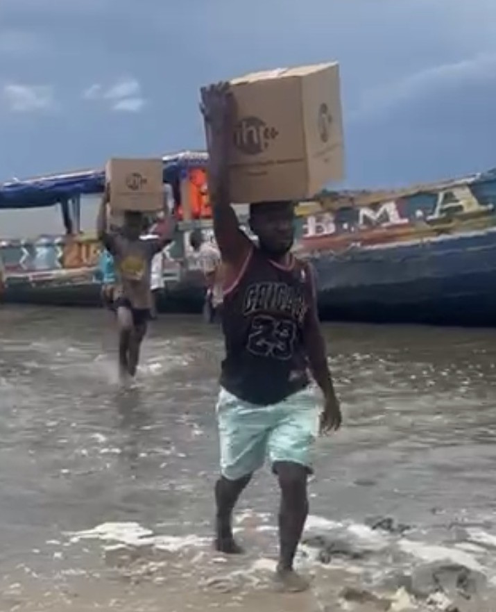 Man getting off board and carrying a box of medicines on his heat