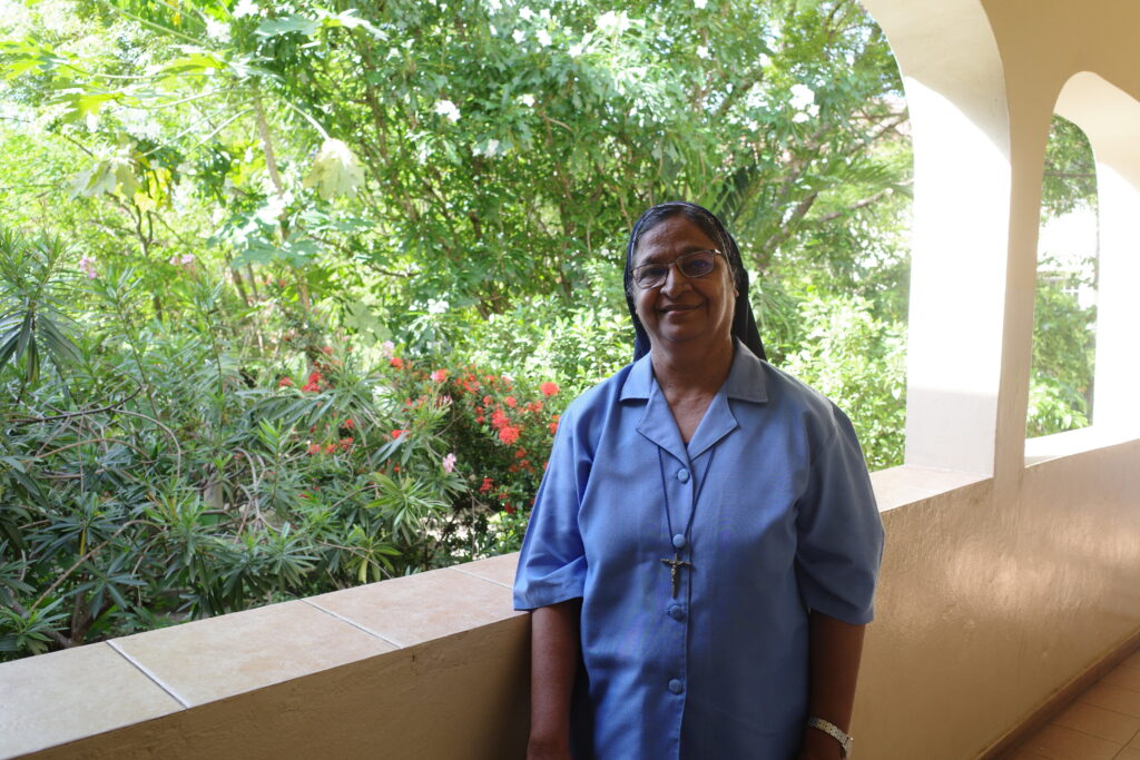 Nun standing in front of a green gree
