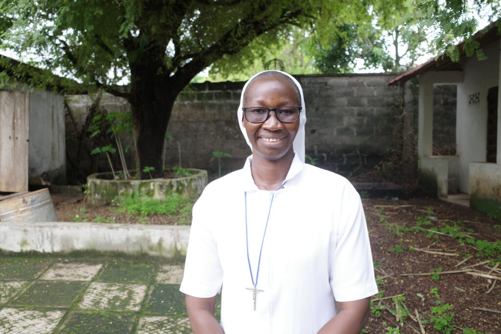 Nun in white standing in a garden